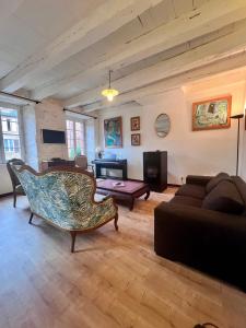 ein Wohnzimmer mit Sofa und Tisch in der Unterkunft Grande Maison pour 8 personnes - Bourg de Meyssac in Meyssac