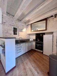 eine Küche mit einem weißen Kühlschrank und einer Spüle in der Unterkunft Grande Maison pour 8 personnes - Bourg de Meyssac in Meyssac