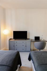 a bedroom with a dresser with a tv and a desk at FamilienZeit Apartments in Bremerhaven
