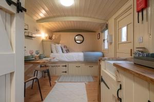 a small kitchen with a bed in a tiny house at Walltree House in Brackley