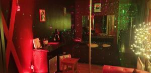 LOVEROOM avec JACCUZI Villa Les Pins في Marolles: غرفة مع طاولة وغرفة مع أضواء +3 صور