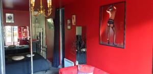 LOVEROOM avec JACCUZI Villa Les Pins في Marolles: جدار احمر فيه صورة لامرأة في مرآة