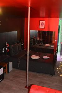 LOVEROOM avec JACCUZI Villa Les Pins في Marolles: غرفة بسريرين وجدار احمر