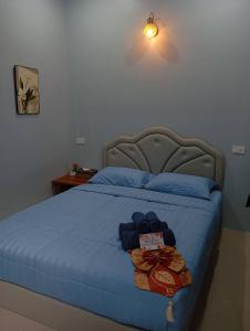 a bedroom with a blue bed with a blue comforter at SK Hometel Samui Airport in Bang Rak Beach