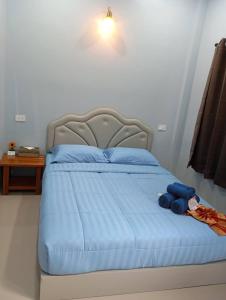 a bed with blue sheets and blue towels on it at SK Hometel Samui Airport in Bang Rak Beach