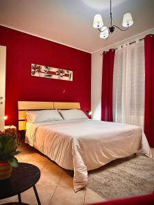 a bedroom with red walls and a large bed at Il corbezzolo in Linguaglossa