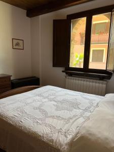 a bedroom with a white bed with a window at Villa Gorghe in San Severino Lucano