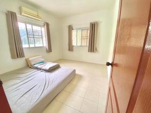 a room with a bed and two windows at Pensuk Home in Ban Yang
