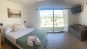a bedroom with a bed and a couch and a window at Casa Luoni Hotel Boutique & Aparts in San Luis +41 photos