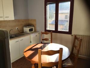 a kitchen with a table and chairs and a microwave at Apartment in cozy house with terrace in Aspres-sur-Buëch +10 photos