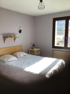 a bedroom with a large bed and a window at Apartment in cozy house with terrace in Aspres-sur-Buëch