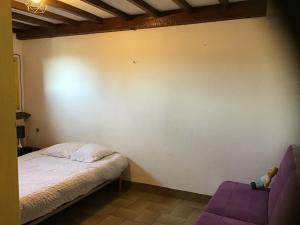 a bedroom with a bed and a purple chair at Apartment in cozy house with terrace in Aspres-sur-Buëch