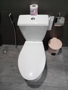 a white toilet in a bathroom with a phone at SK Hometel Samui Airport in Bang Rak Beach