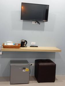a desk with a flat screen tv on a wall at SK Hometel Samui Airport in Bang Rak Beach