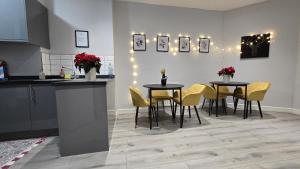 a kitchen with two tables and yellow chairs at Soho Guest House Room 6 in London