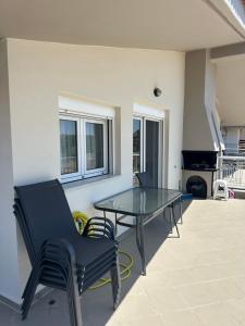 a patio with a glass table and chairs at ST Fanari Home 2025 in Fanárion