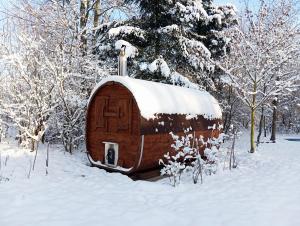 Una caseta de madera para perros con nieve encima en Chatka zimorodka, en Pielgrzymka