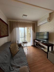 a living room with a couch and a piano at Confort Club 907 - Barra Velha- SC in Barra Velha