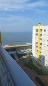 a view from a balcony of a building and the ocean at Confort Club 907 - Barra Velha- SC in Barra Velha
