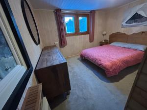 a small bedroom with a bed and a desk at Chalet Le Renard Du Lac in Les Gets