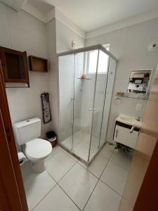 a bathroom with a shower and a toilet and a sink at Confort Club 907 - Barra Velha- SC in Barra Velha