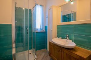 een badkamer met een wastafel en een glazen douche bij Pandora Sea View by Solturelba in Capoliveri