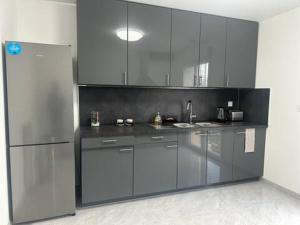 a kitchen with stainless steel cabinets and a refrigerator at maison individuelles pour 16 personnes in Lieusaint +17 photos