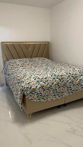a bed with a quilt on it in a room at maison individuelles pour 16 personnes in Lieusaint