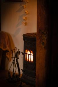 Una pequeña estufa en la esquina de una habitación. en Chatka zimorodka, en Pielgrzymka 45 fotos más