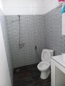 Un baño con inodoro y ducha. en Villa 2 chambres salon piscine saly, en Mbour