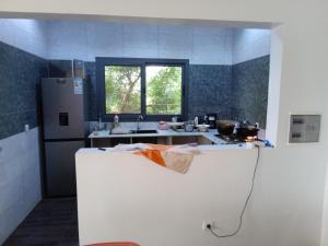 una cocina con fregadero y refrigerador en Villa 2 chambres salon piscine saly, en Mbour