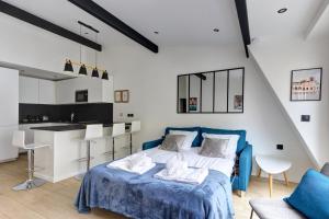 1 Schlafzimmer mit einem blauen Bett und einer Küche in der Unterkunft Suite New Delhi - Superbe Appartement in Suresnes