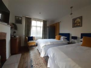 a hotel room with two beds and a chair at Grail Cottage in Glastonbury