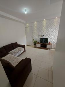a living room with a couch and a tv at Condomínio São Francisco in Petrolina