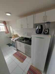 a small kitchen with white cabinets and a refrigerator at Condomínio São Francisco in Petrolina +15 photos