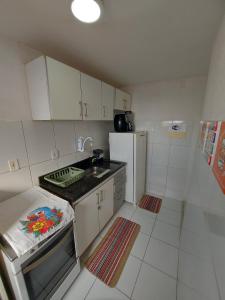 a small kitchen with a sink and a refrigerator at Condomínio São Francisco in Petrolina