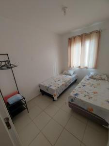 a bedroom with two beds and a chair in it at Condomínio São Francisco in Petrolina