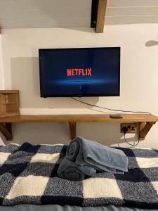 a flat screen tv on a wall in a bedroom at The carriage in Three Cocks Junction