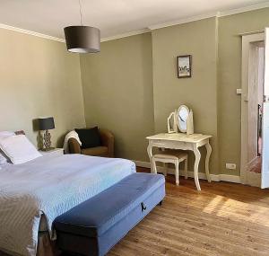 a bedroom with a bed and a table with a mirror at La Maison Haute in La Fosse-de-Tigné