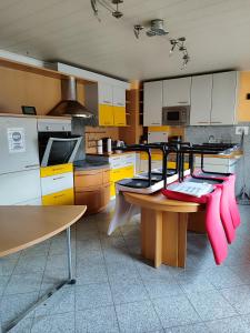 a kitchen with yellow and white cabinets and a table at Ferienwohnung Belvie 3 in Butzbach