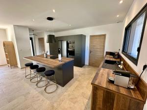 a kitchen with a island with bar stools at Villa Provençale in Le Thor