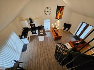 a living room with a couch and a clock on the wall at Brooke View Barns No2 in Norwich