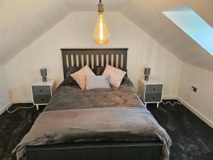 a bedroom with a large bed with pillows on it at Brooke View Barns No2 in Norwich