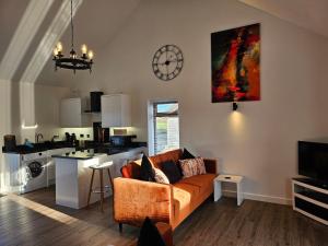 a living room with a couch and a kitchen at Brooke View Barns No2 in Norwich