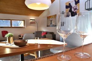 two wine glasses sitting on a table in a living room at Haus MUMO in Bad Hofgastein