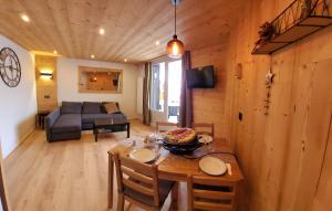 una sala da pranzo e un soggiorno con tavolo e divano. di Douillet 33 m² piscine et sauna - 6 pers a LʼAlpe-dʼHuez