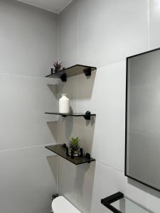 DiniginanSpaces by Mono Unit 326的一间带白色墙壁、卫生间和书架的浴室