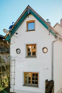 une maison blanche avec des fenêtres et un toit dans l'établissement Historisches Cottage in der Altstadt - für 6 Gäste, à Bad Tölz