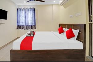 a bedroom with a large bed with red pillows at SS Residency in Bengaluru