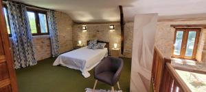 a bedroom with a bed and a chair in a room at Séjour à la campagne en Périgord Noir in La Cassagne